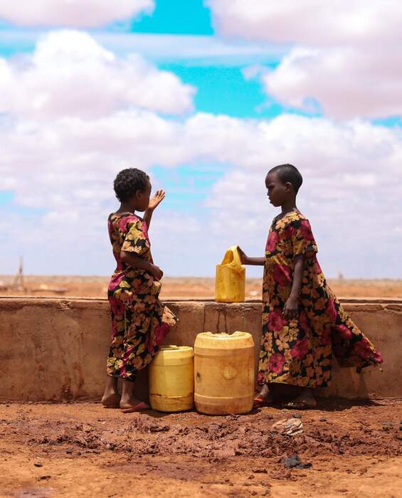 Two children at a water point in Kenya - drinking water thanks to development aid.