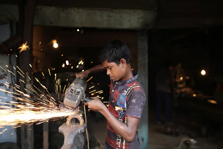 A young man works with dangerous tools in Bangladesh - Development aid is still needed to fight child labor.