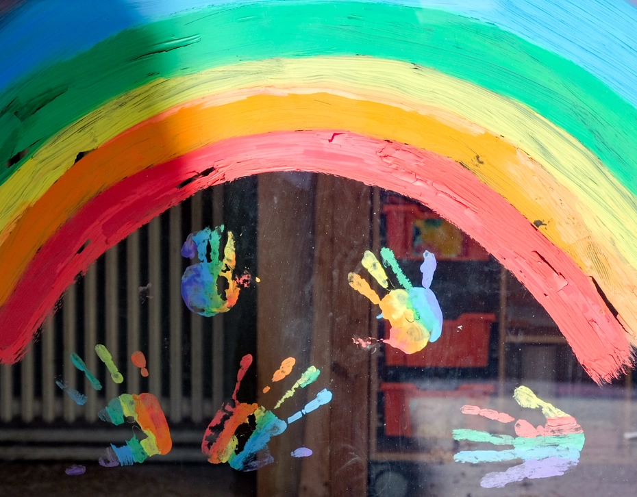 Colorful rainbow with painted handprints – Swiss Solidarity enables hope for children in need. 