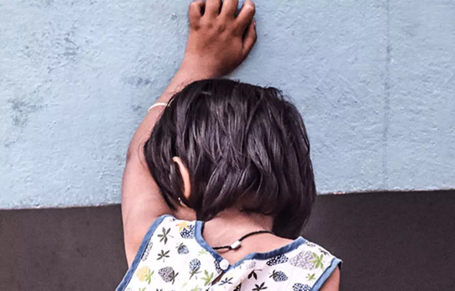 Helping children in distress A child leaning against a wall - a silent call for protection.