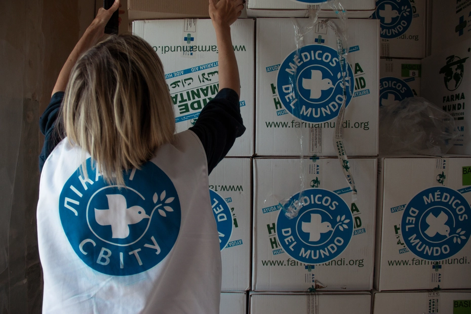 A Médecins du Monde aid worker stacks medical parcels - essential support for restoring healthcare in Ukraine after the bombardments.