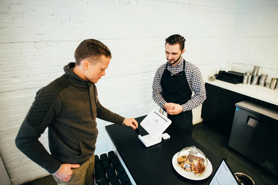 Employee at checkout talking to customer – involve your customers by turning loyalty points or purchases into meaningful support.