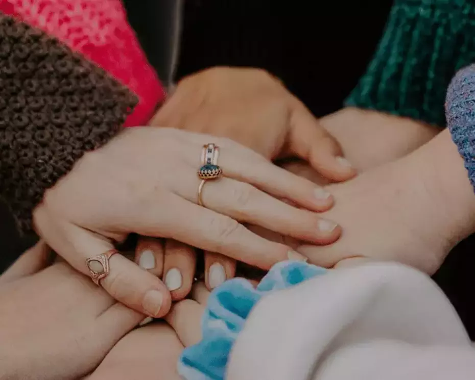 Superimposed hands illustrate solidarity, collective commitment and human support.