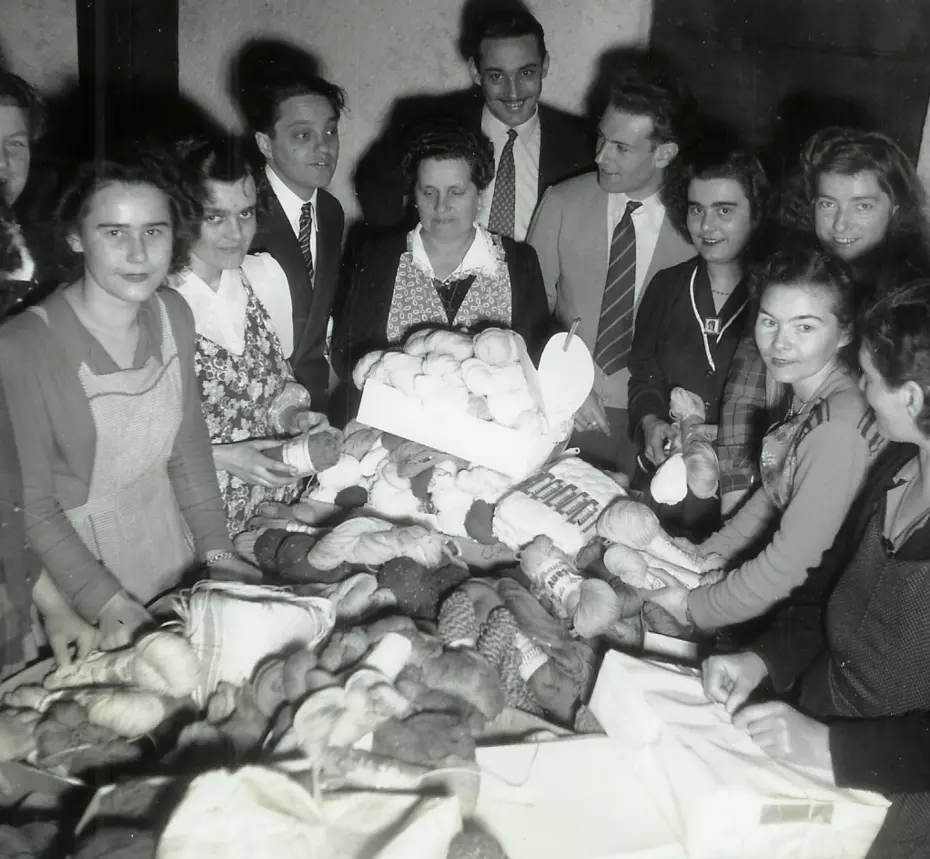 People gathering yarn at a donation table – 1951 campaign to support those suffering from extreme cold.