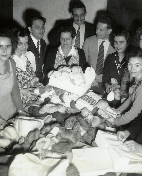 People gathering yarn at a donation table – 1951 campaign to support those suffering from extreme cold.